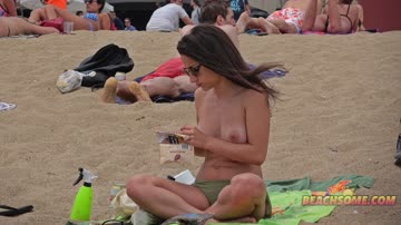 Topless teen enjoys music on beach